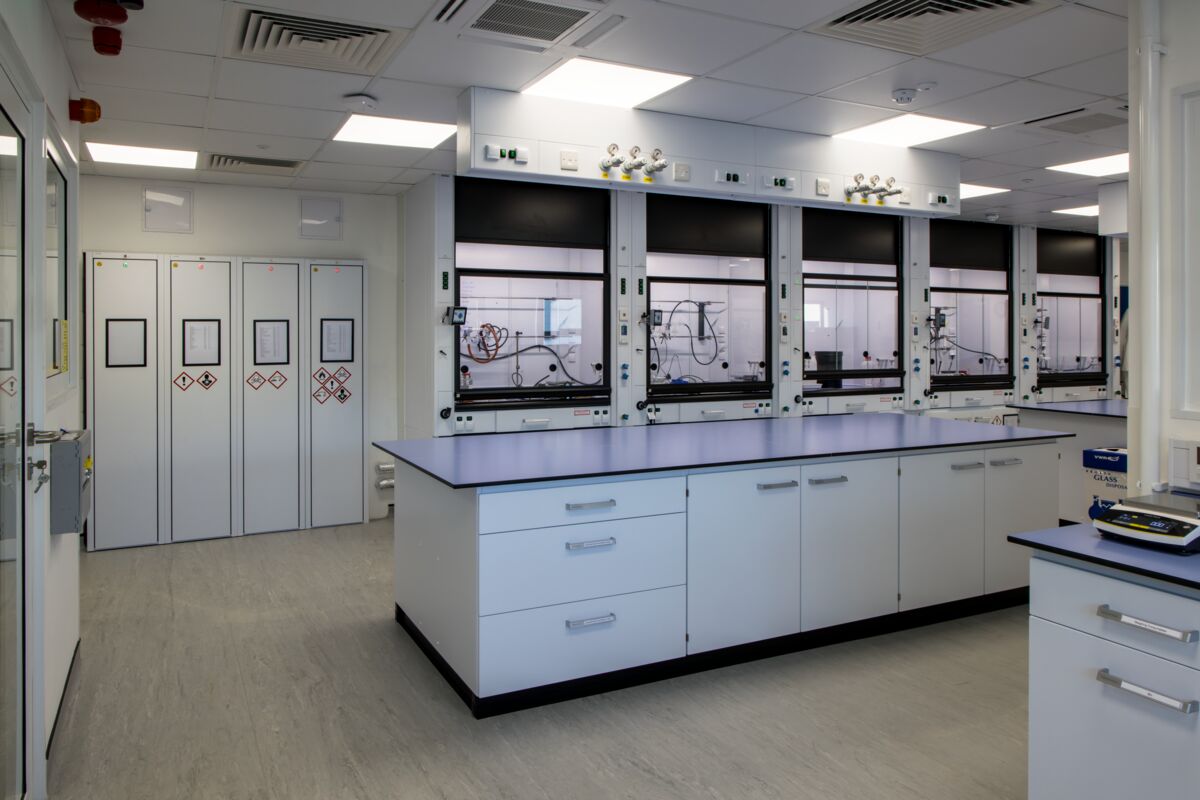 An empty laboratory with five fume hoods