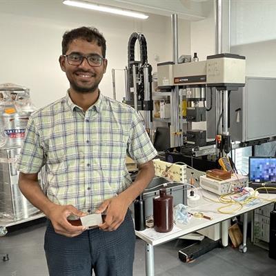 Ashwath Pazhani holding a piece of composite material in the lab