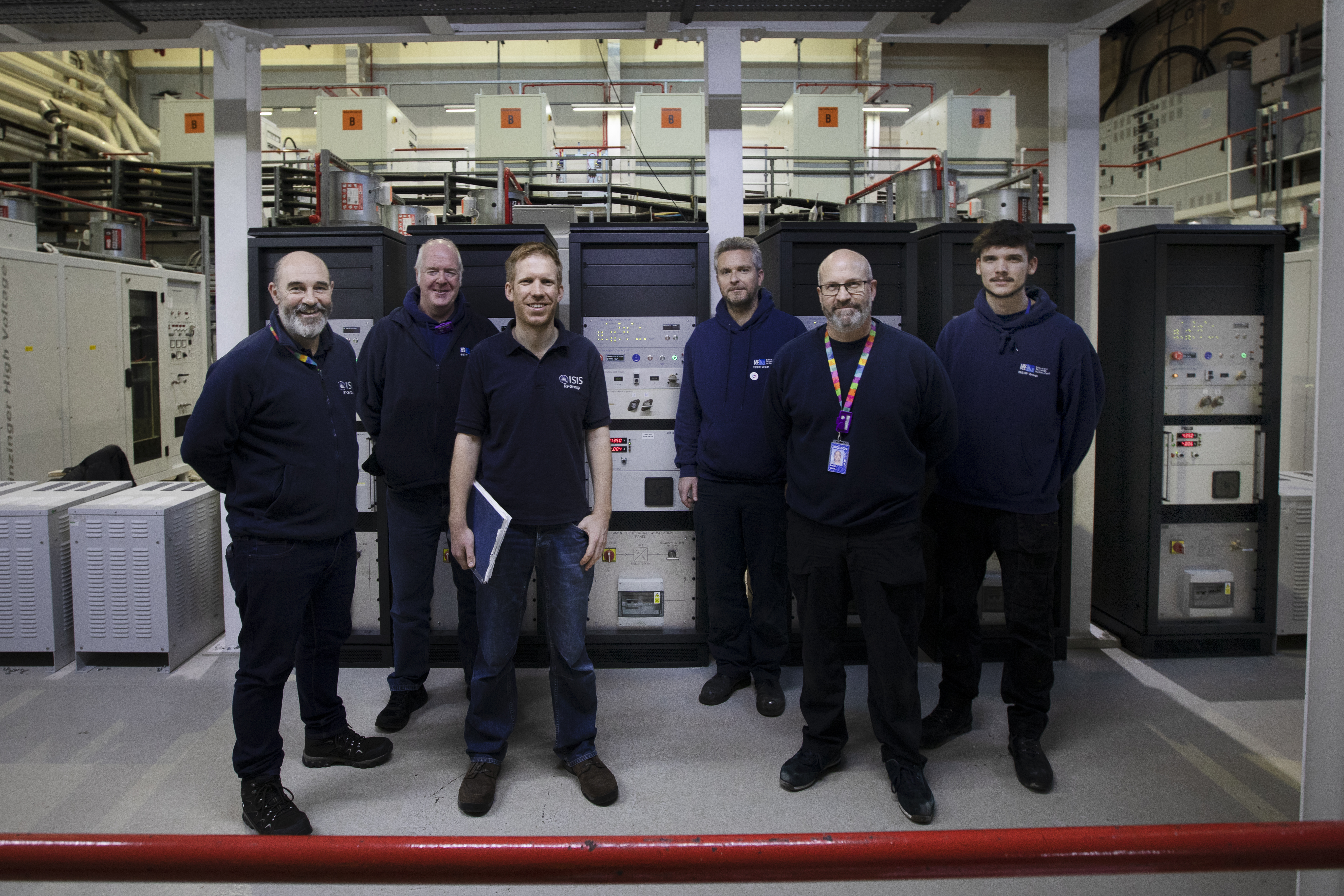 Group of men in front of some control racks