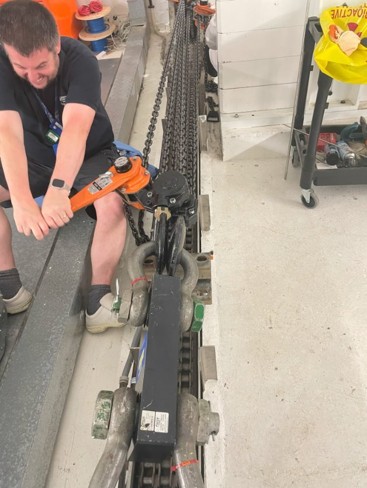 A man smiling, using manual techniques to move the trolley